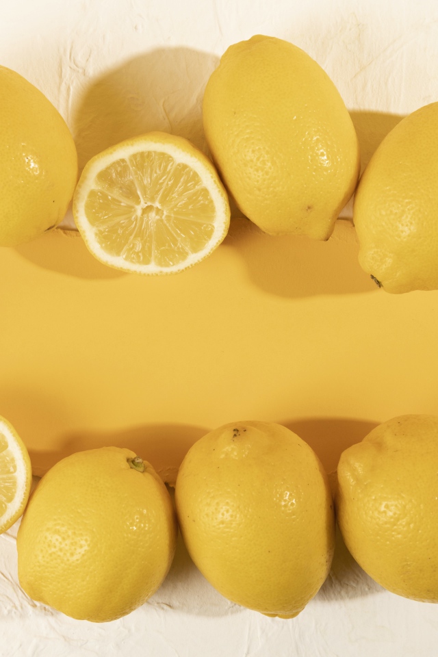 Желтые лимоны на белом фоне с листом бумаги