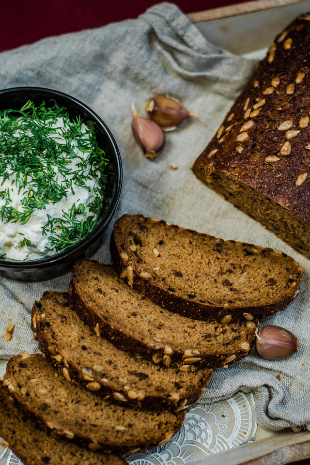 Свежий хлеб с зернами на столе с соусом и чесноком