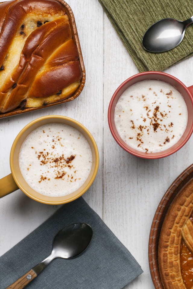 Свежая выпечка и две кружки молока на столе