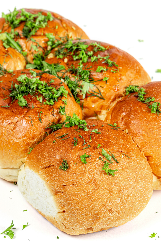 Чесночные булочки с зеленью на белом фоне