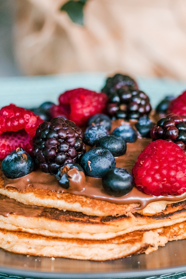 Румяные оладьи с ягодами на тарелке 