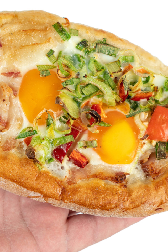 Вкусный свежий хачапури с яйцом и беконом в руке