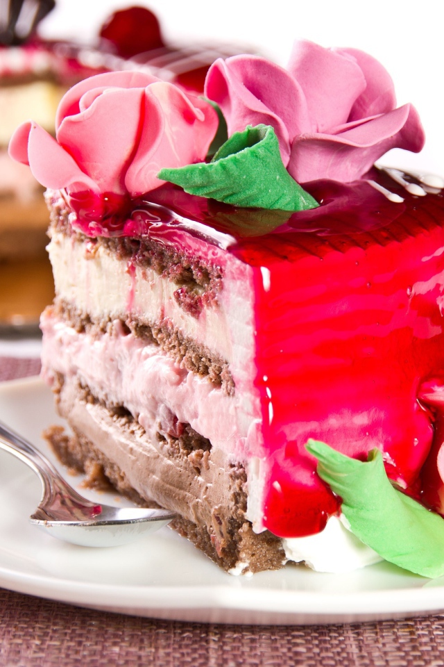 Кусок аппетитного торта декорирован розами из крема