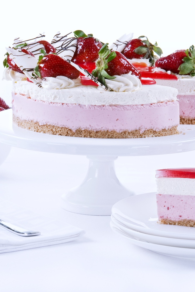 Аппетитный праздничный торт с клубникой на столе 