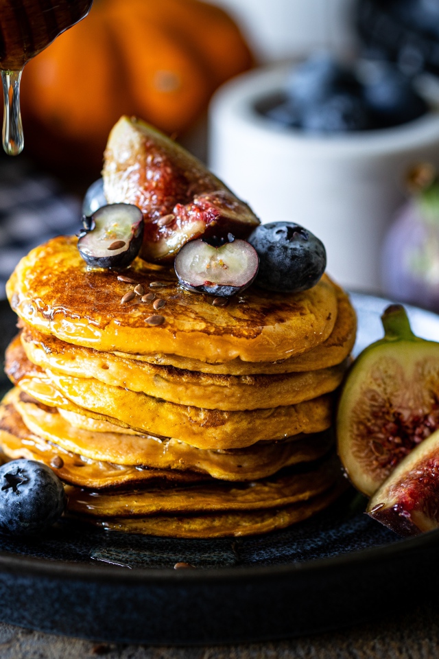 Аппетитные оладьи на тарелке с ягодами черники и инжиром