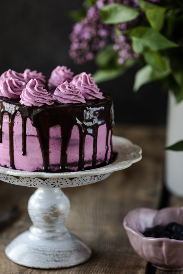 Ягодный торт с шоколадом на столе с сиренью 