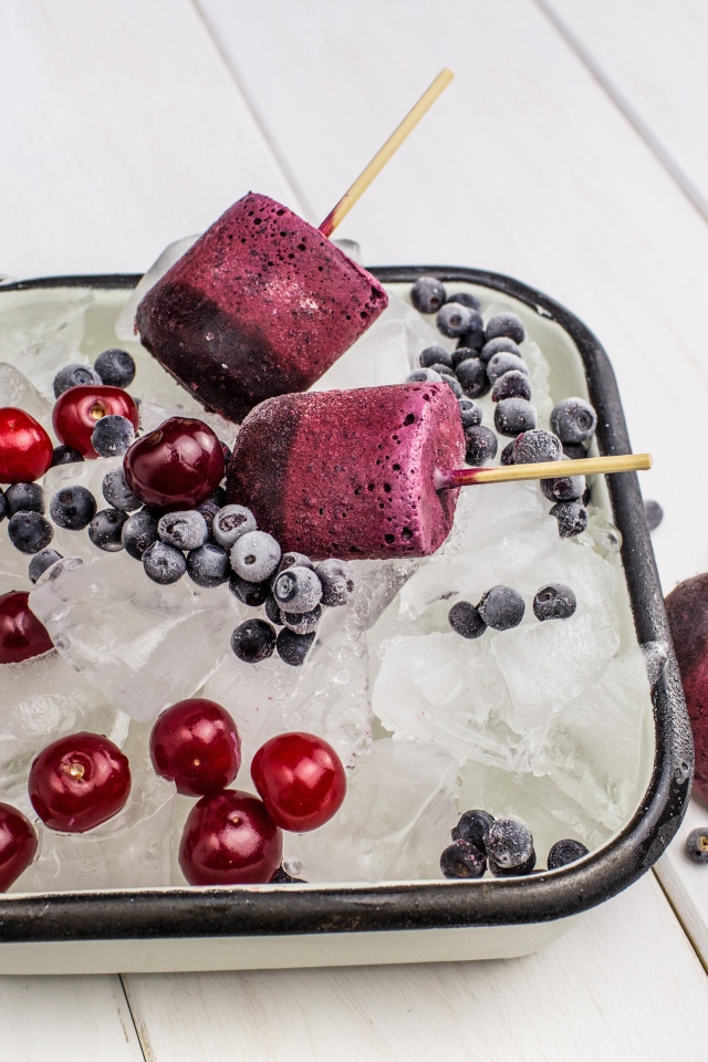 Ягодное мороженое в лотке со льдом, черникой и вишней 