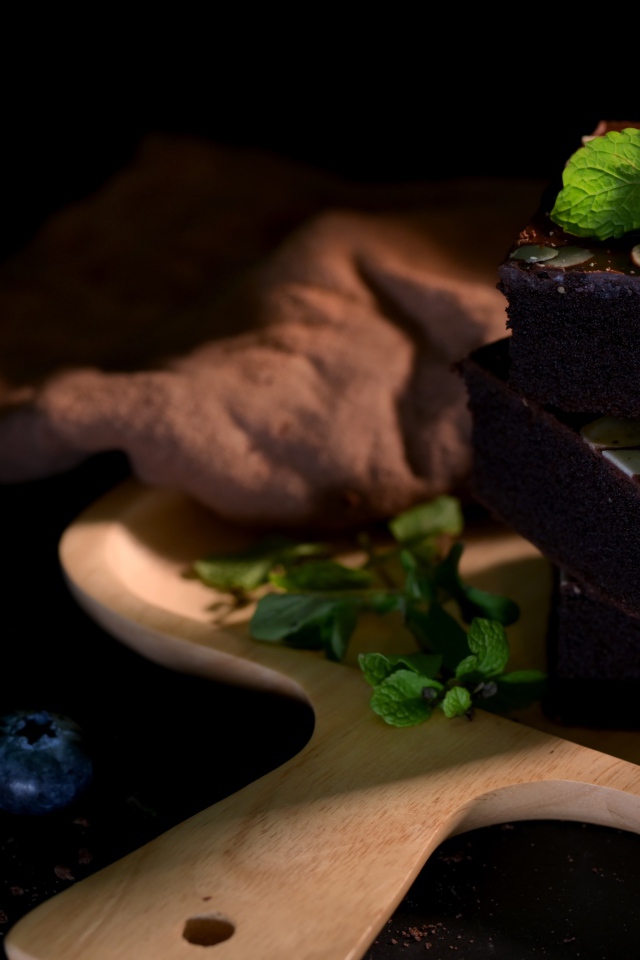 Шоколадный десерт брауни на доске с ягодам черники 