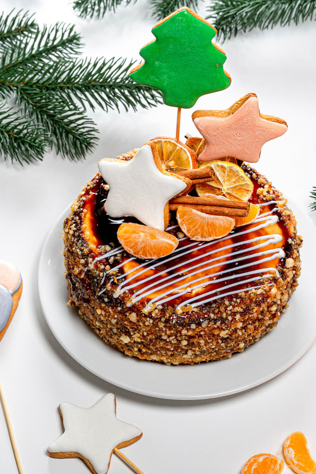 Торт с мандаринами и печеньем на столе с еловой веткой