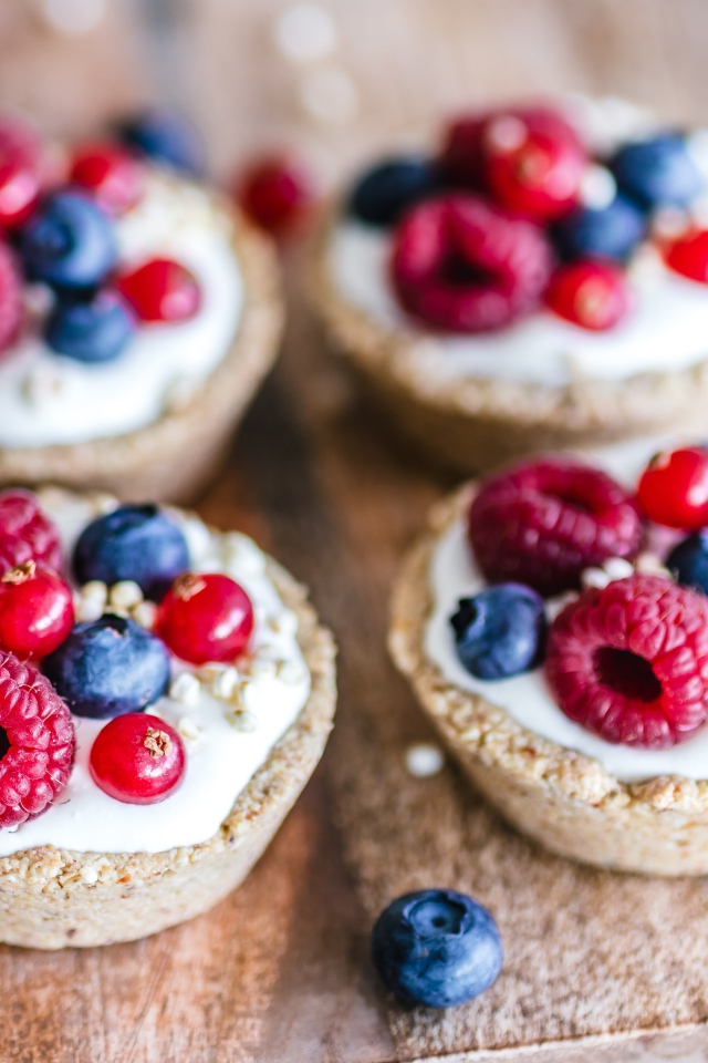 Пирожные с кремом и ягодами на столе крупным планом