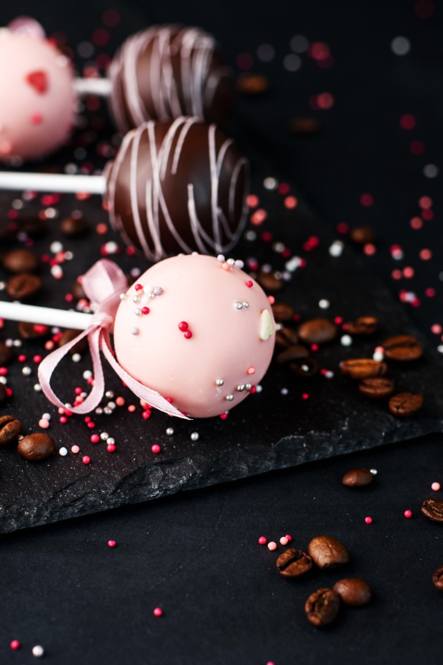 Шоколадные шарики на палочке на столе с кофейными зернами