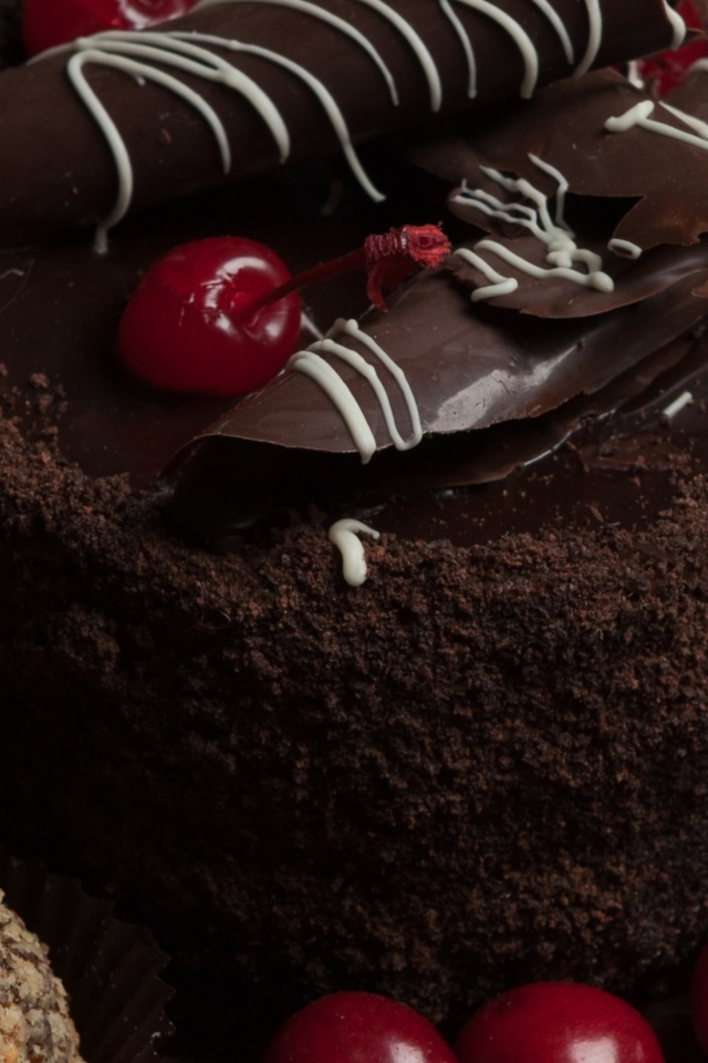 Шоколадный торт с конфетами и вишней на столе 