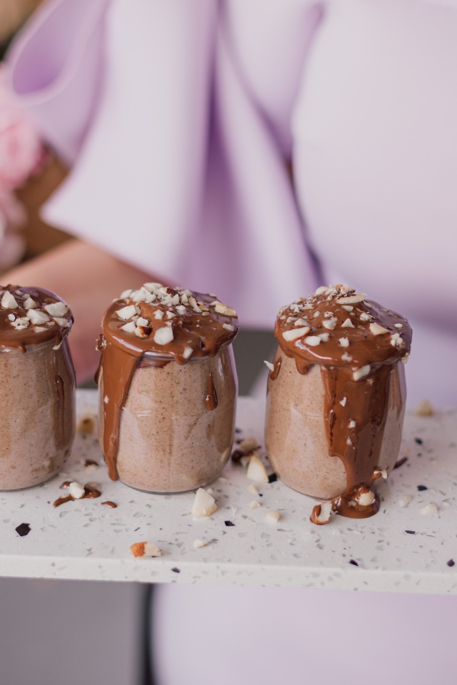 Шоколадный десерт в банках в руках у девушки