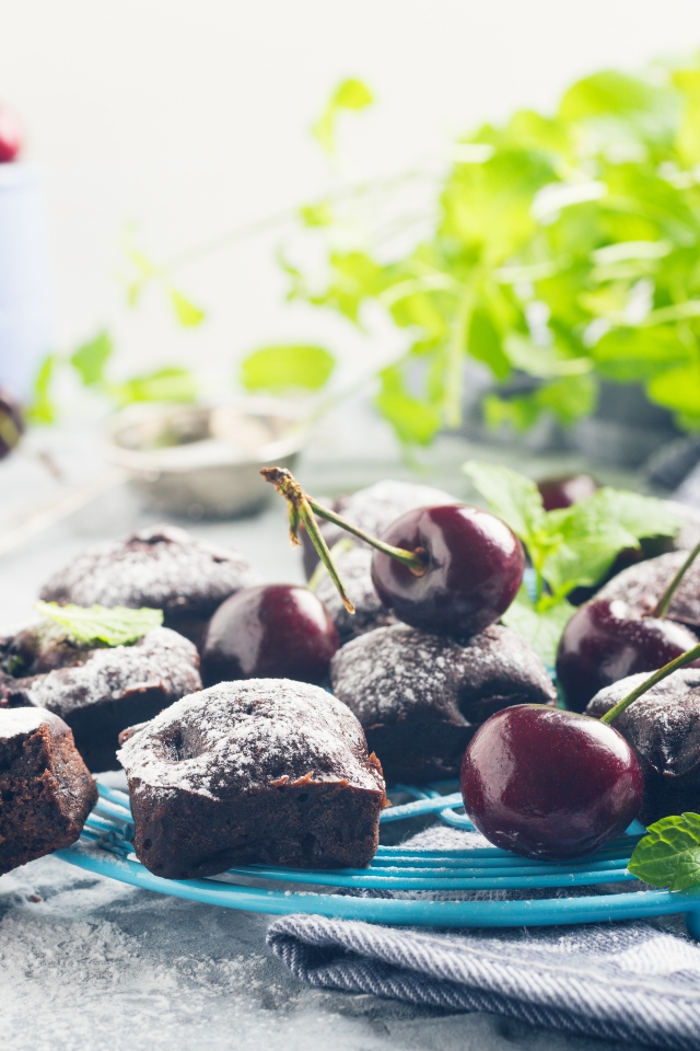 Шоколадные кексы на тарелке с ягодами черешни 