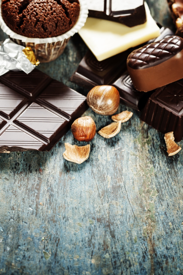 Шоколад на столе с орехами, кексами и конфетами 