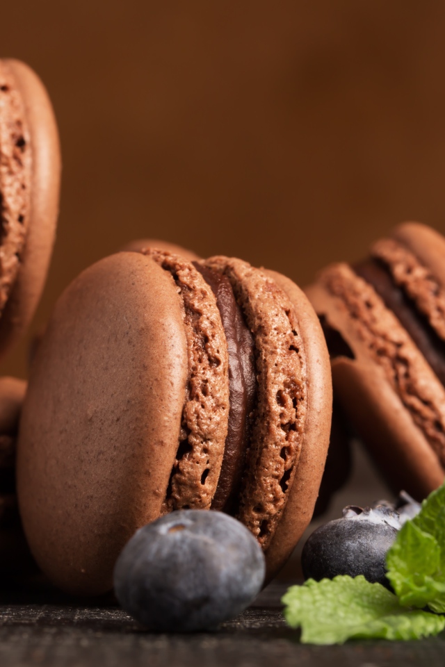 Шоколадный десерт макарон на столе с черникой 