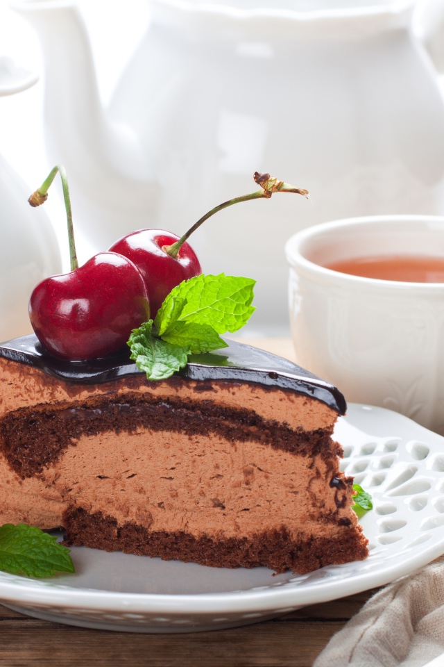 Торт с суфле в шоколаде с ягодами черешни на столе с чаем