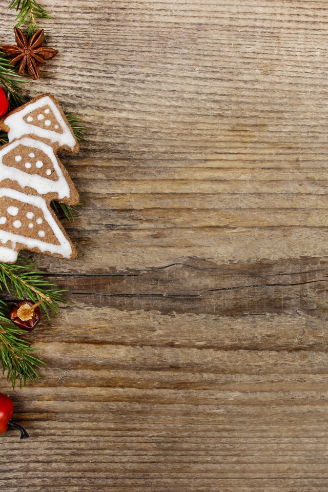 Рождественское печенье с еловой веткой на деревянном фоне 