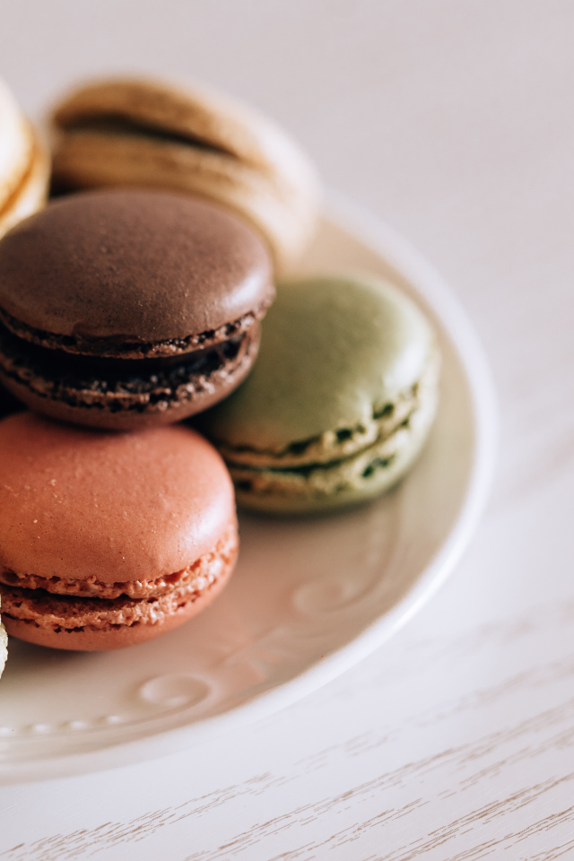 Разноцветный свежий десерт макарон на большой тарелке 