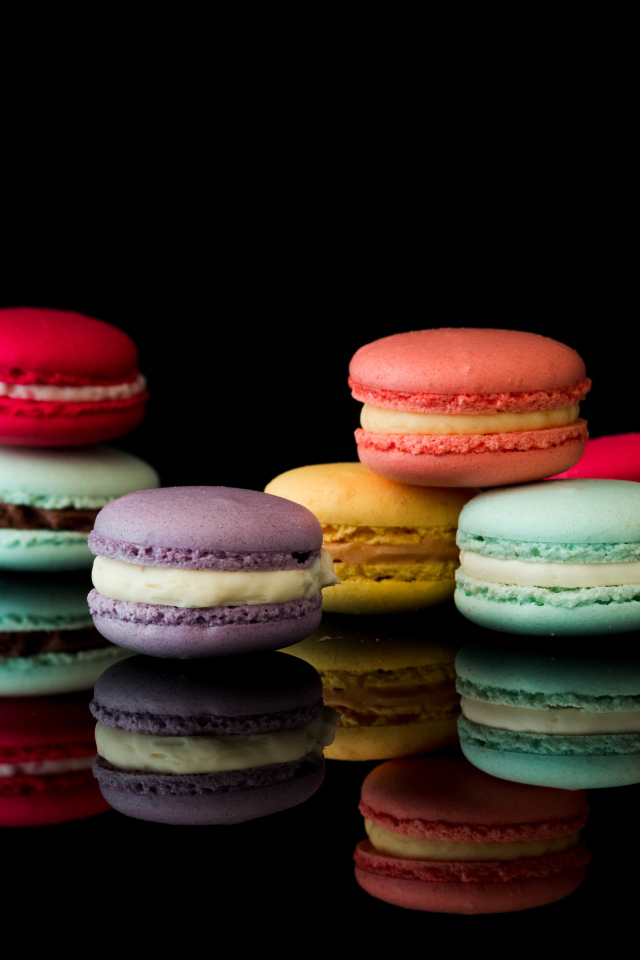 Разноцветный десерт макарун на черном фоне