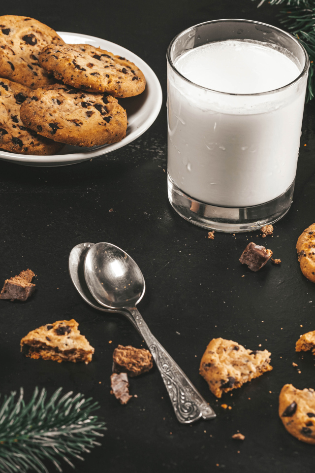 Печенье на столе с молоком и еловыми ветками