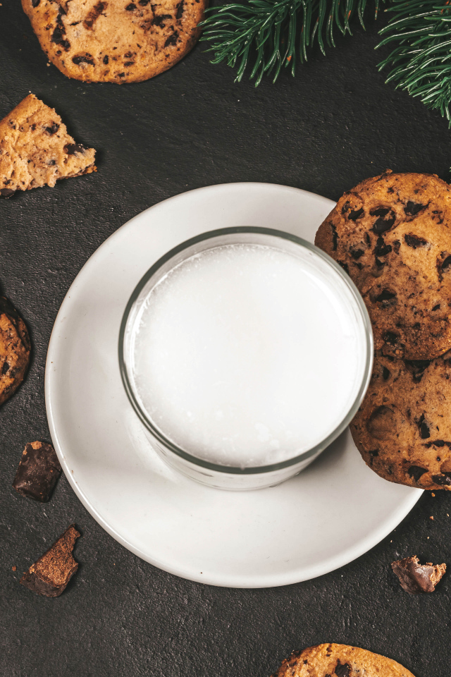 Печенье с шоколадом на столе со стаканом молока 