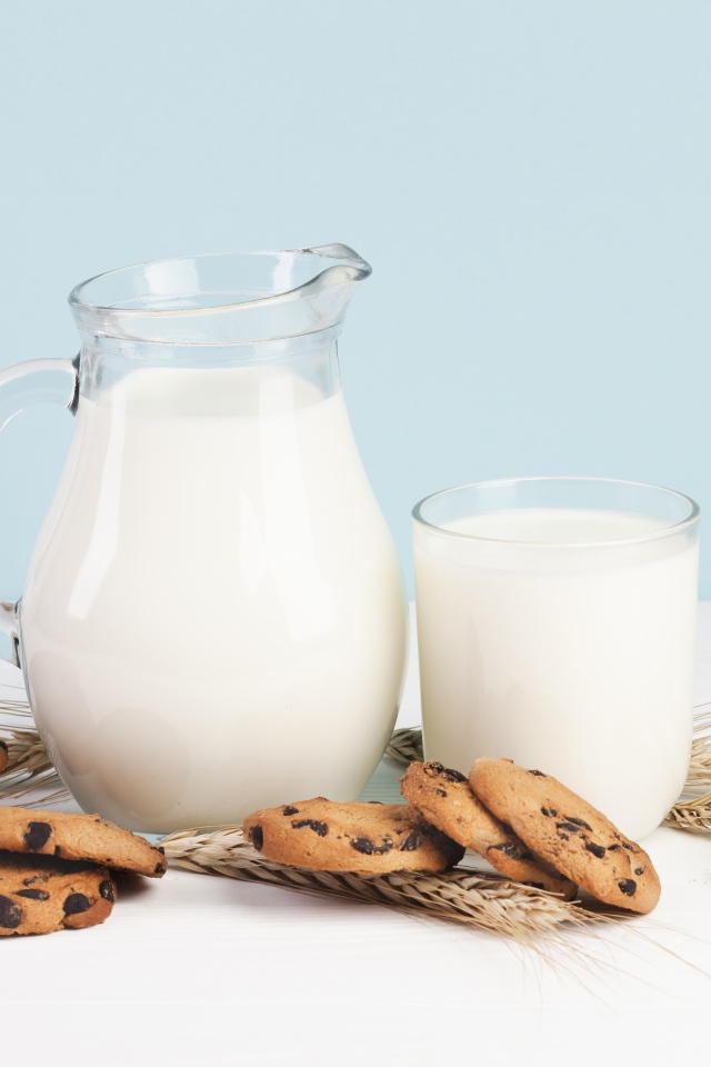 Печенье с шоколадом на столе с молоком и колосьями пшеницы