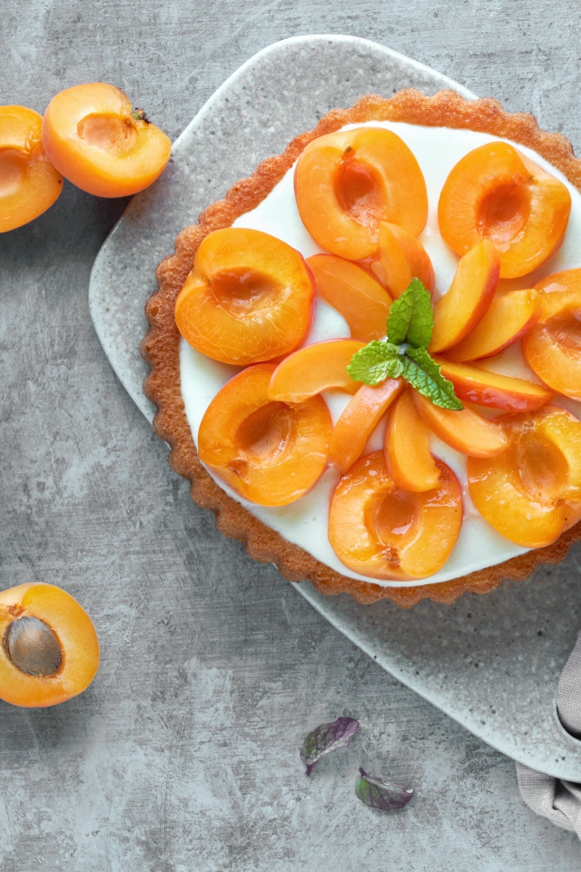 Пирог с кремом и абрикосами на столе 