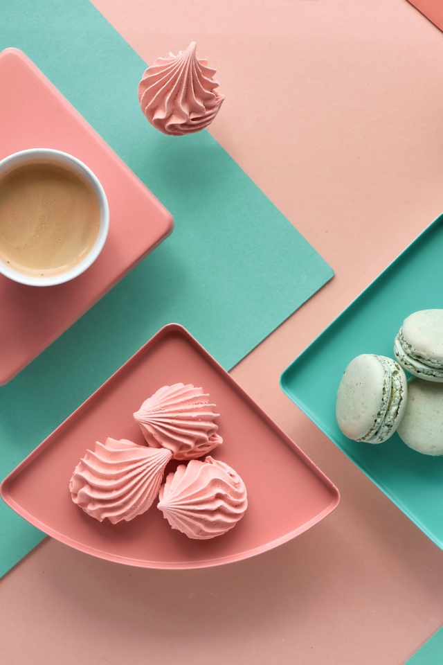 Чашка какао на столе с зефиром и десертом макарон 