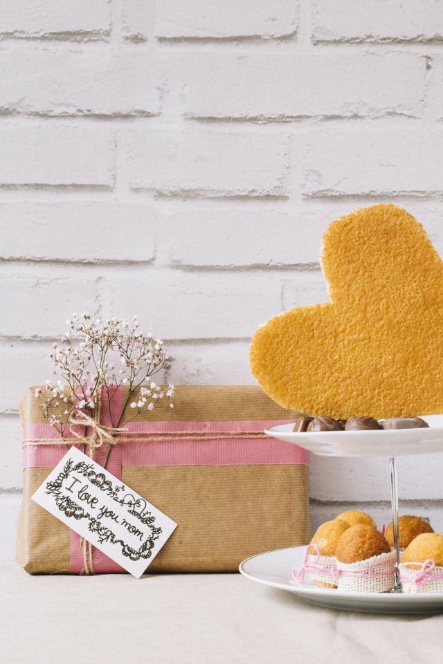 Кексы на тарелке на столе с подарком для любимой 