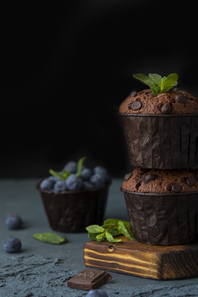 Кексы с шоколадом на столе с ягодами черники на столе 