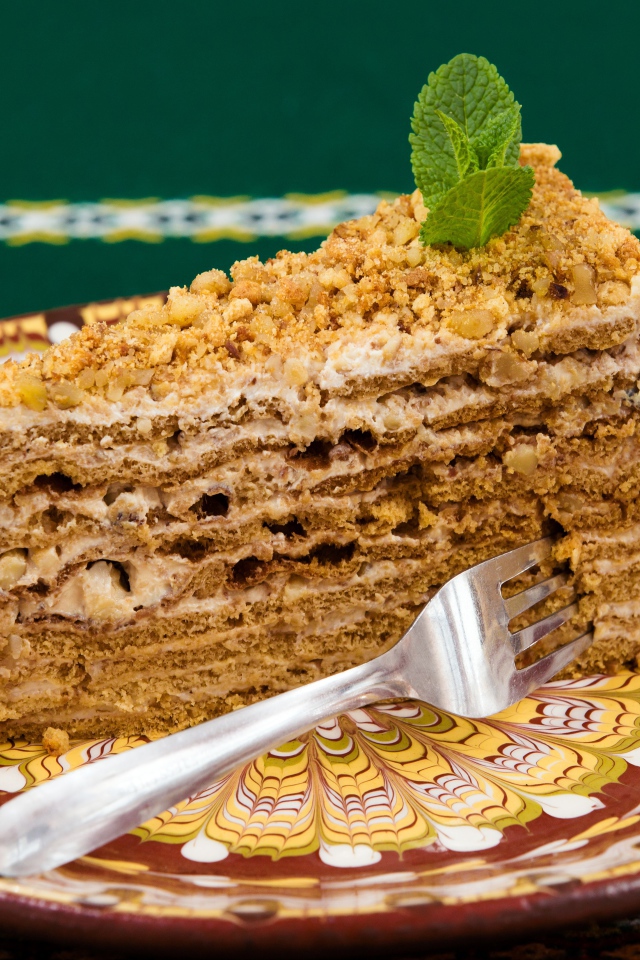 Вкусный медовый торт с орехами на красивой тарелке 