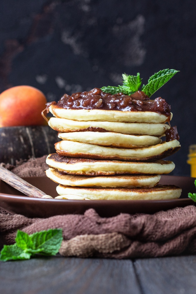 Вкусные оладьи на тарелке с джемом