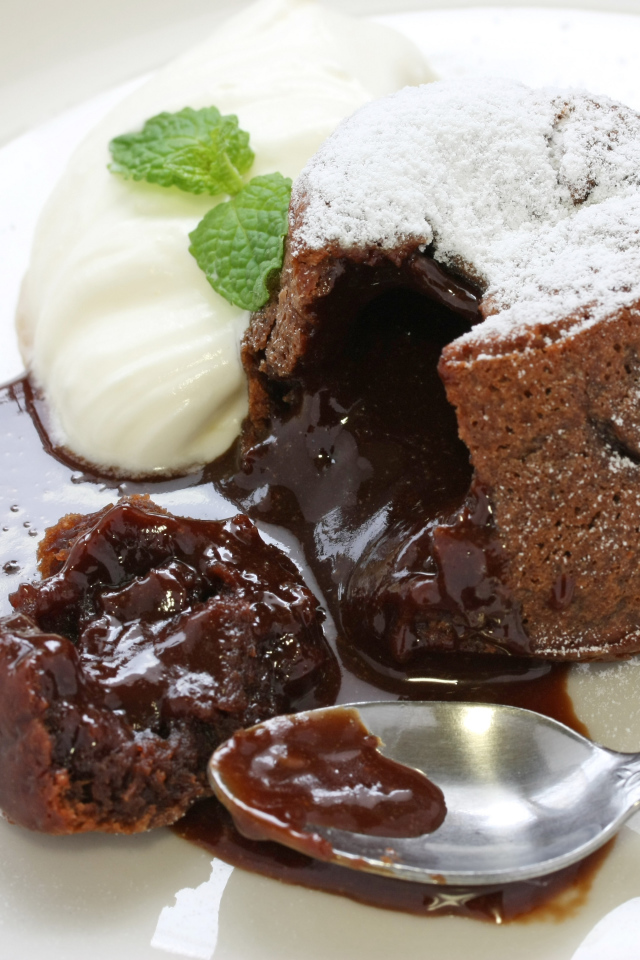 Десерт с шоколадом и сливками на белой тарелке 