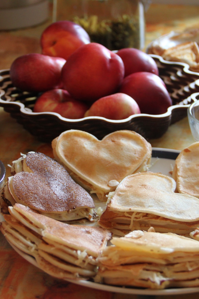 Блины с начинкой на столе с нектарином