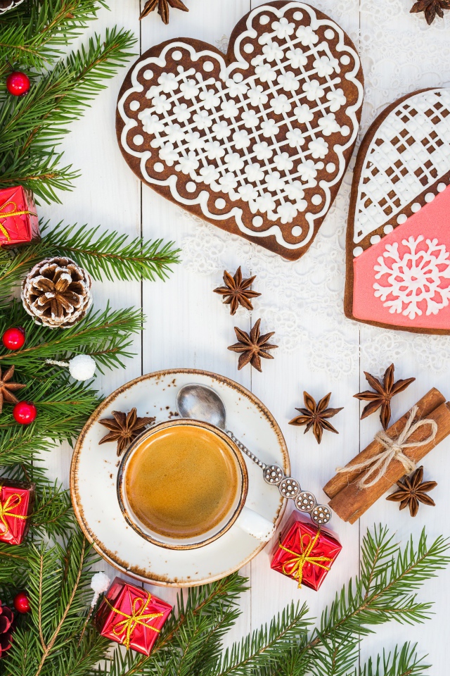 Печенье в форме сердца на столе с чашкой кофе и еловой веткой