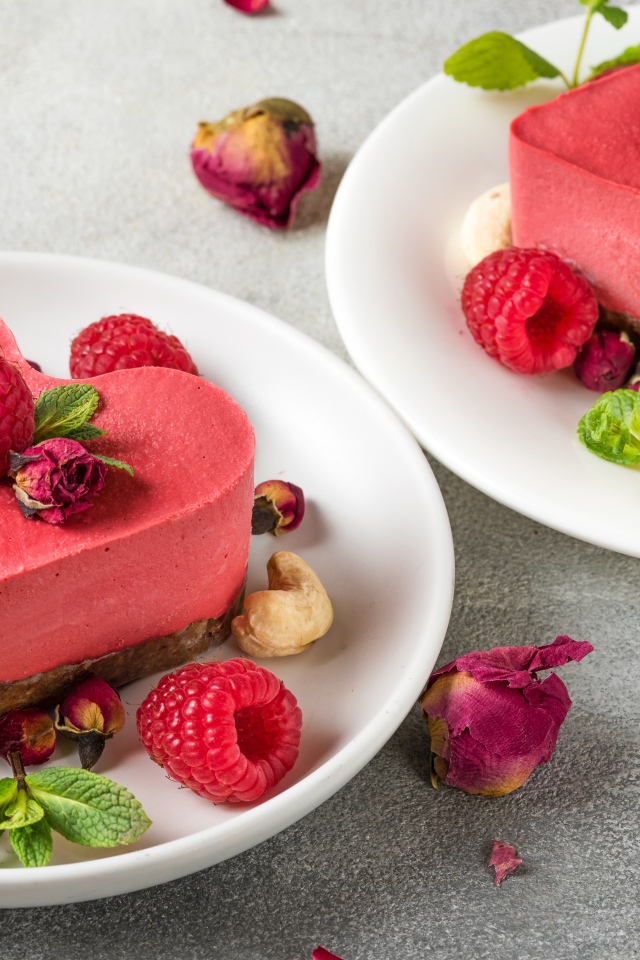 Фруктовое суфле в форме сердца на тарелке с малиной и орехами 