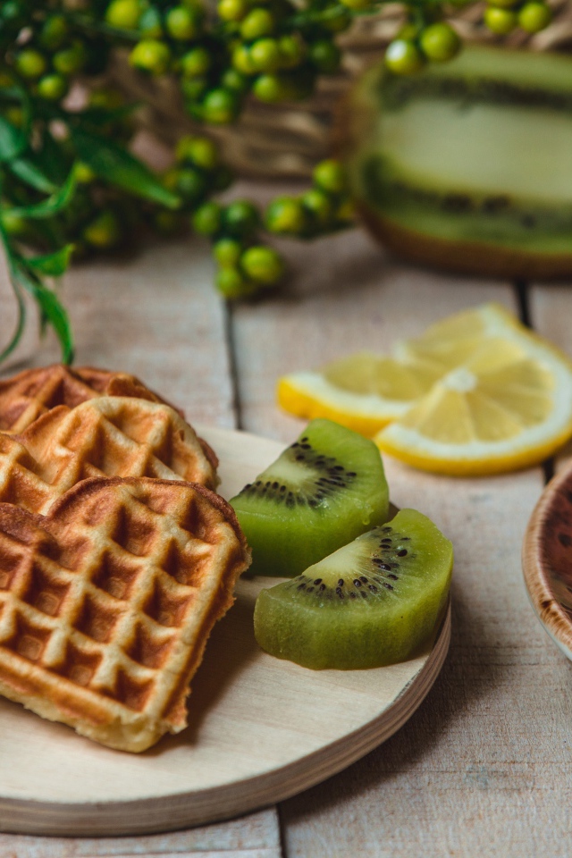 Вафли в форме сердца на доске с киви и чашкой кофе