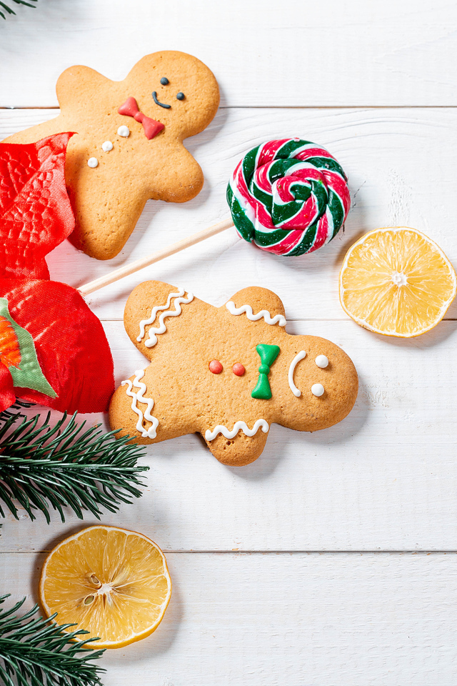 Праздничное печенье с леденцом и еловой веткой на столе 