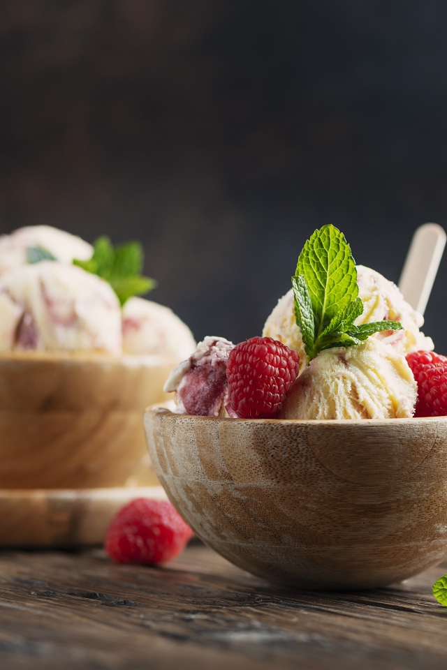 Шарики мороженого в деревянных мисках с ягодами малины