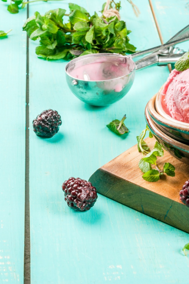 Шарики мороженого на столе с ягодами черники и мятой