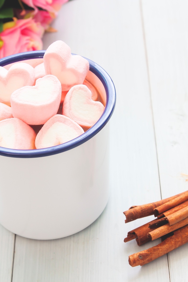 Железная чашка какао с маршмеллоу на столе с корицей 