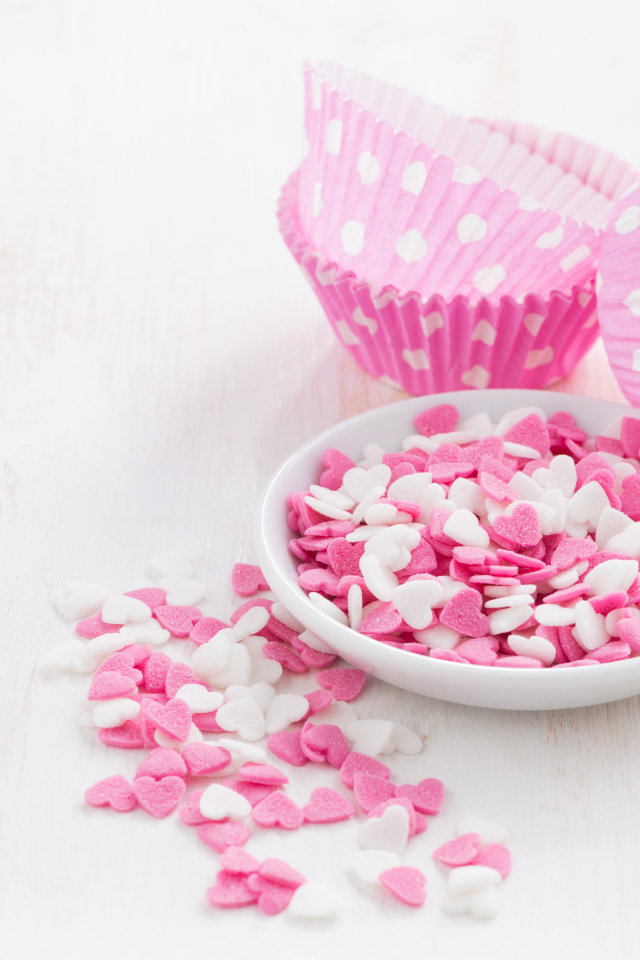 Маленькие белые и розовые сердечки на столе 