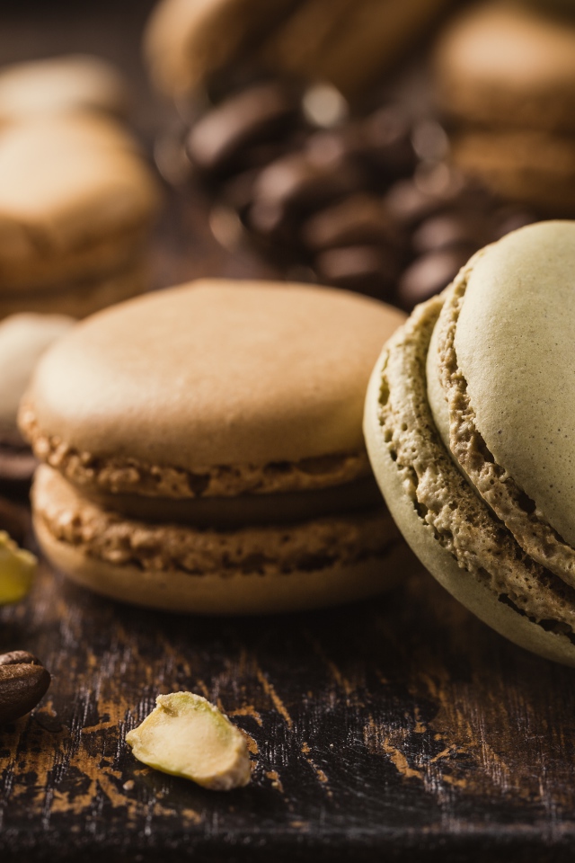 Десерт макарун на столе с кофейными зернами