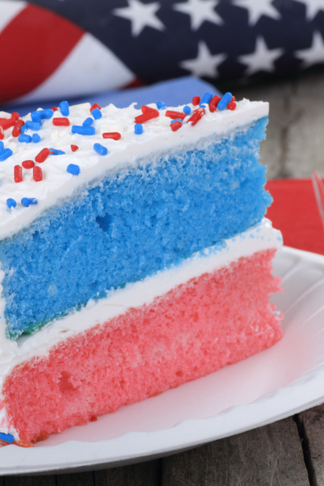 Разноцветный торт на тарелке с кремом