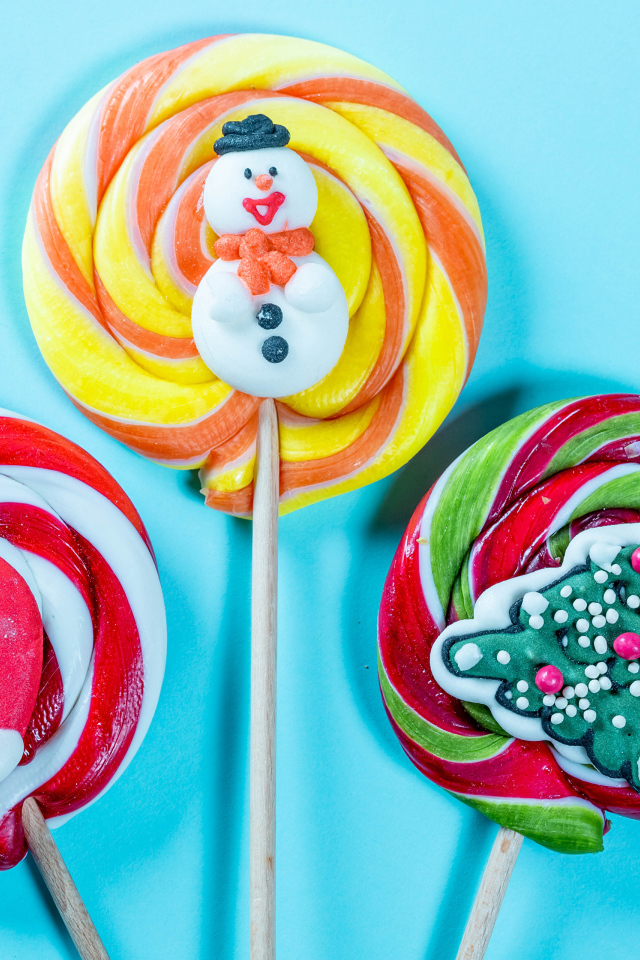Разноцветные леденцы на палочках на голубом фоне