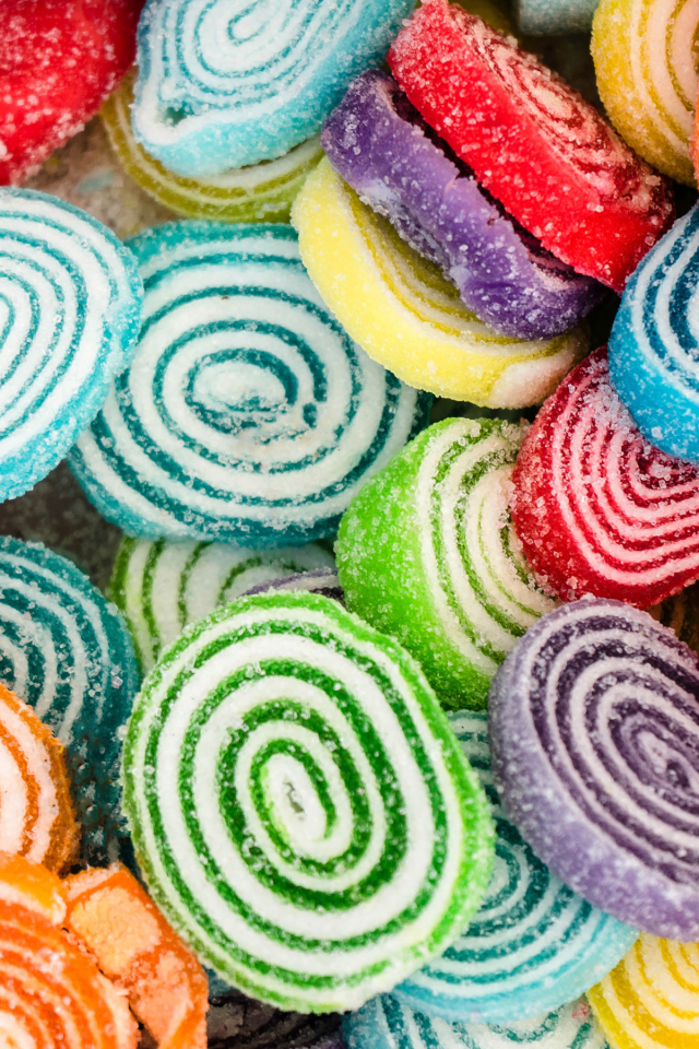 Разноцветный спиральный мармелад в сахаре крупным планом