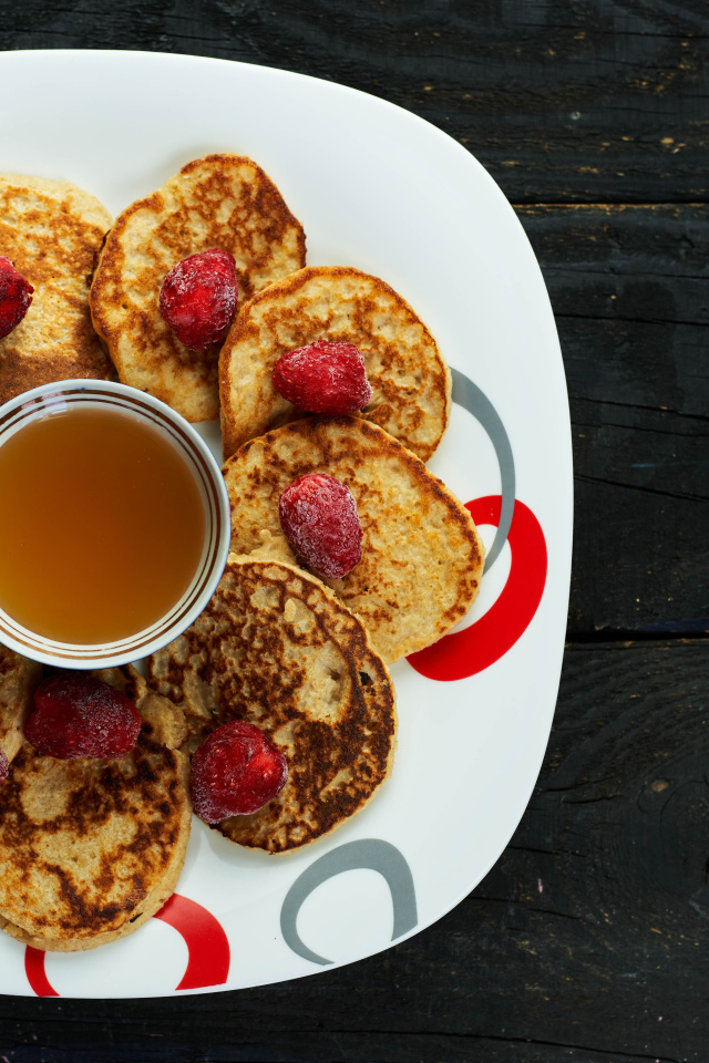 Оладьи на тарелке с клубникой и медом