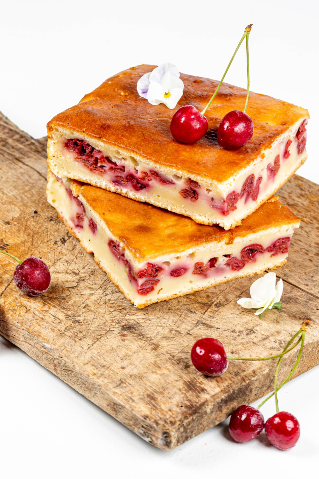 Пирог с вишнями на доске на белом фоне