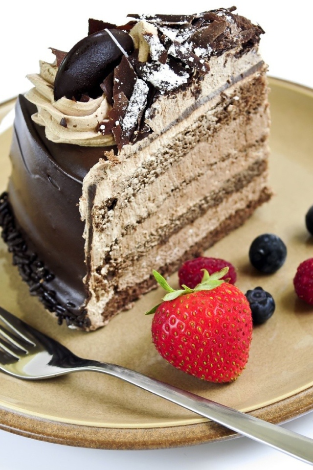 Кусок торта с ягодами на тарелке на белом фоне